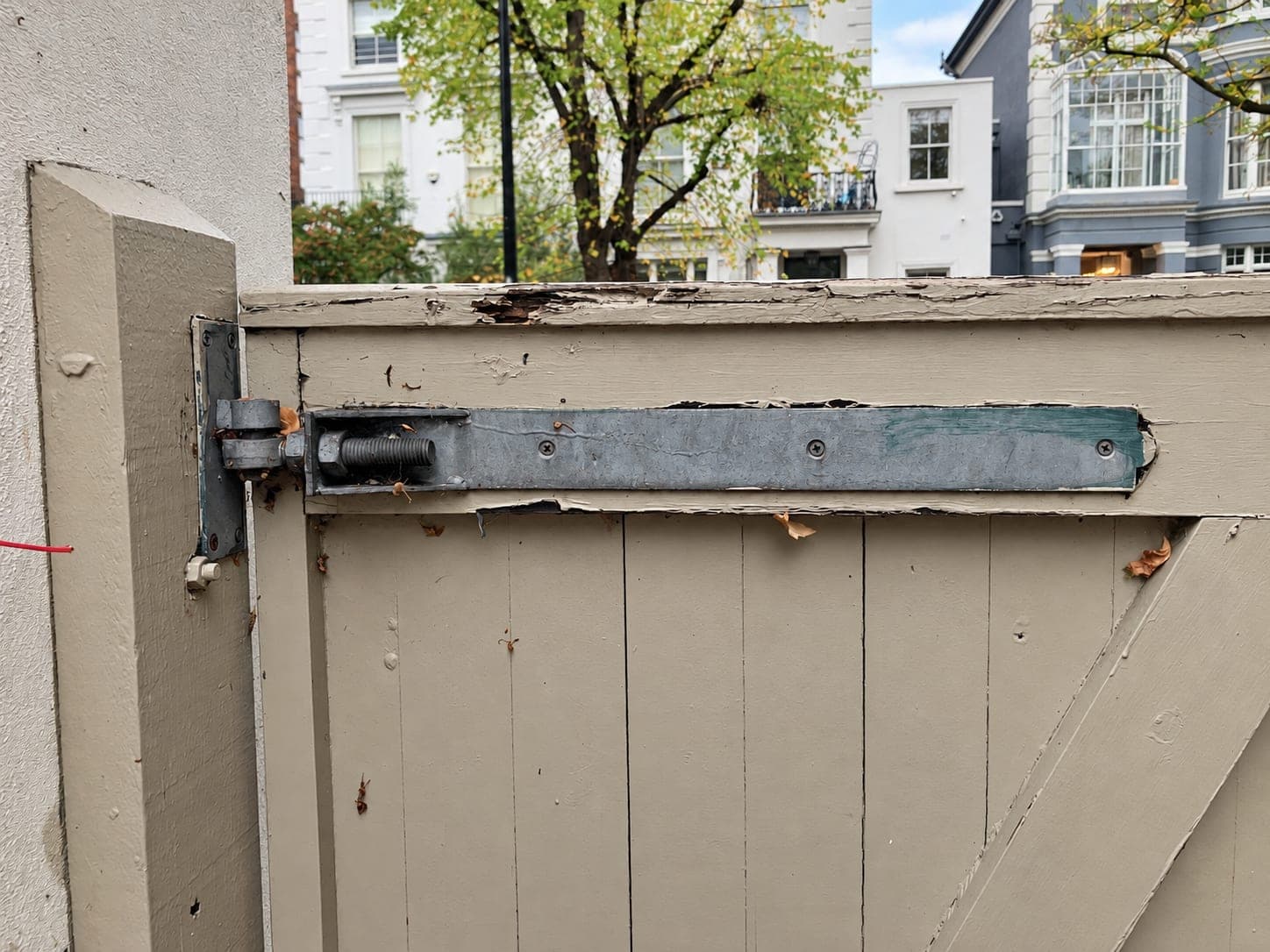 Galvanised hinge bar and drop bolt fitted to the back of a timber gate, London