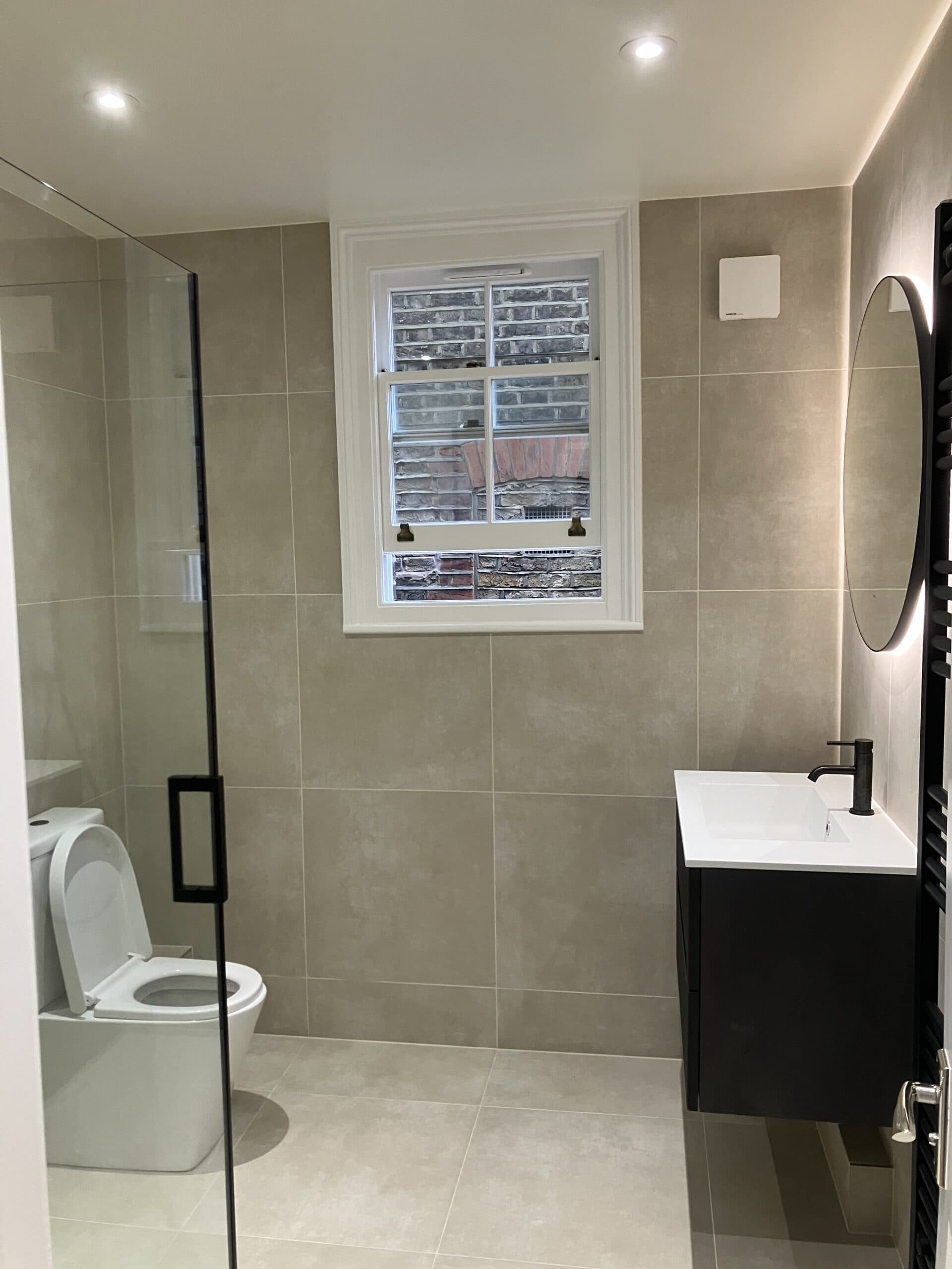 Bathroom renovations in London with large-format wall tiles, walk-in shower and vanity unit